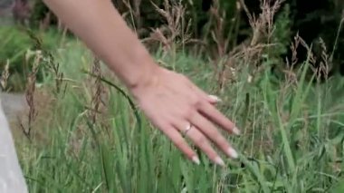 Kadının eli çimlere değiyor.