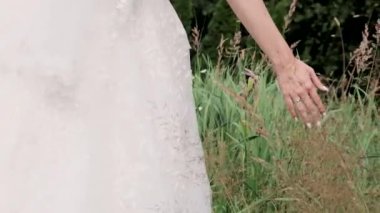 Gelin elleriyle çimenlere dokunur.