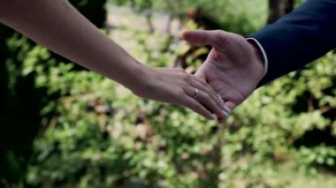 Yeşil bir geçmişi olan yeni evlilerin elleri.