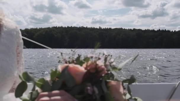 女性の手は水を背景に指で花に触れ — ストック動画