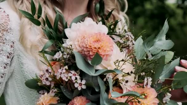 緑の森に大きな花束を持った花嫁が立っています — ストック動画