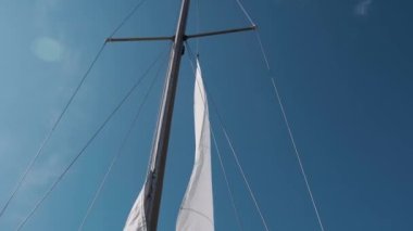 Yelken teknede hazır. Mavi gökyüzüne karşı beyaz yelkenler. Rüzgarlı havada beyaz yelkenler