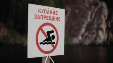 Yüzmek yasak işaretidir. Bulutlu havada Rusça işaret dili yüzmek yasaktır.