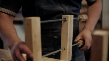  Atölyedeki marangoz. Adam ahşap malzemelerle çalışıyor. Marangoz atölyede ahşap işçiliği yapıyor. İnşaat malzemesi ya da ahşap mobilya üretiyor. Genç marangoz profesyonel aletler kullanır.
