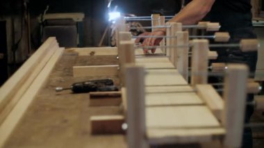  Atölyedeki marangoz. Adam ahşap malzemelerle çalışıyor. Marangoz atölyede ahşap işçiliği yapıyor. İnşaat malzemesi ya da ahşap mobilya üretiyor. Genç marangoz profesyonel aletler kullanır.