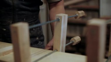  Atölyedeki marangoz. Adam ahşap malzemelerle çalışıyor. Marangoz atölyede ahşap işçiliği yapıyor. İnşaat malzemesi ya da ahşap mobilya üretiyor. Genç marangoz profesyonel aletler kullanır.