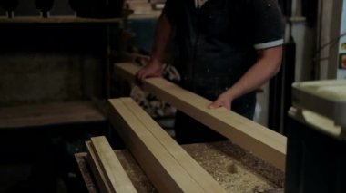 Atölyedeki marangoz. Adam ahşap malzemelerle çalışıyor. Marangoz atölyede ahşap işçiliği yapıyor. İnşaat malzemesi ya da ahşap mobilya üretiyor. Genç marangoz profesyonel aletler kullanır.