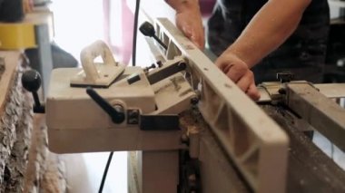  Atölyedeki marangoz. Adam ahşap malzemelerle çalışıyor. Marangoz atölyede ahşap işçiliği yapıyor. İnşaat malzemesi ya da ahşap mobilya üretiyor. Genç marangoz profesyonel aletler kullanır.