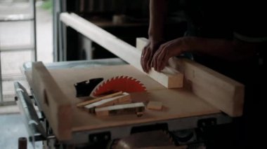  Atölyedeki marangoz. Adam ahşap malzemelerle çalışıyor. Marangoz atölyede ahşap işçiliği yapıyor. İnşaat malzemesi ya da ahşap mobilya üretiyor. Genç marangoz profesyonel aletler kullanır.