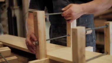 Atölyedeki marangoz. Adam ahşap malzemelerle çalışıyor. Marangoz atölyede ahşap işçiliği yapıyor. İnşaat malzemesi ya da ahşap mobilya üretiyor. Genç marangoz profesyonel aletler kullanır.