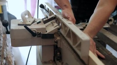 Atölyedeki marangoz. Adam ahşap malzemelerle çalışıyor. Marangoz atölyede ahşap işçiliği yapıyor. İnşaat malzemesi ya da ahşap mobilya üretiyor. Genç marangoz profesyonel aletler kullanır.