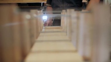 Atölyedeki marangoz. Adam ahşap malzemelerle çalışıyor. Marangoz atölyede ahşap işçiliği yapıyor. İnşaat malzemesi ya da ahşap mobilya üretiyor. Genç marangoz profesyonel aletler kullanır.