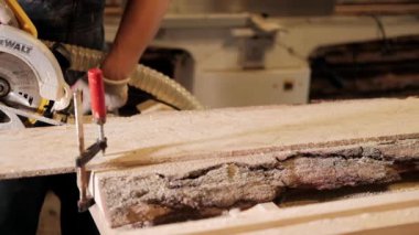 Atölyedeki marangoz. Adam ahşap malzemelerle çalışıyor. Marangoz atölyede ahşap işçiliği yapıyor. İnşaat malzemesi ya da ahşap mobilya üretiyor. Genç marangoz profesyonel aletler kullanır.