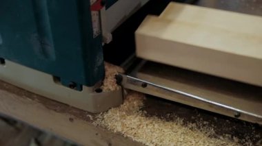 Atölyedeki marangoz. Adam ahşap malzemelerle çalışıyor. Marangoz atölyede ahşap işçiliği yapıyor. İnşaat malzemesi ya da ahşap mobilya üretiyor. Genç marangoz profesyonel aletler kullanır.