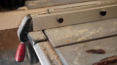 Atölyedeki marangoz. Adam ahşap malzemelerle çalışıyor. Marangoz atölyede ahşap işçiliği yapıyor. İnşaat malzemesi ya da ahşap mobilya üretiyor. Genç marangoz profesyonel aletler kullanır.