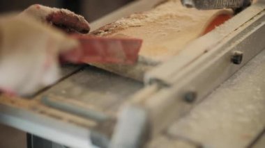 Atölyedeki marangoz. Adam ahşap malzemelerle çalışıyor. Marangoz atölyede ahşap işçiliği yapıyor. İnşaat malzemesi ya da ahşap mobilya üretiyor. Genç marangoz profesyonel aletler kullanır.