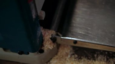 Atölyedeki marangoz. Adam ahşap malzemelerle çalışıyor. Marangoz atölyede ahşap işçiliği yapıyor. İnşaat malzemesi ya da ahşap mobilya üretiyor. Genç marangoz profesyonel aletler kullanır.