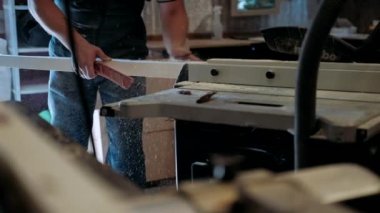 Atölyedeki marangoz. Adam ahşap malzemelerle çalışıyor. Marangoz atölyede ahşap işçiliği yapıyor. İnşaat malzemesi ya da ahşap mobilya üretiyor. Genç marangoz profesyonel aletler kullanır.