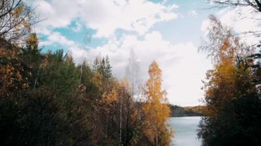 Sonbahar havası kayalık tepelerin tepeleri ve dağların tepeleri kızıl günbatımı ışınlarıyla. Gölün ya da nehrin kıyısı, renkli ağaçlar ve çalılar, park ya da rezerv.Sonbahar dağ manzaraları rezervuarın yanında.