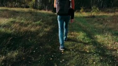 Turistler soğuk bir sonbahar gününde arazide yürürler.