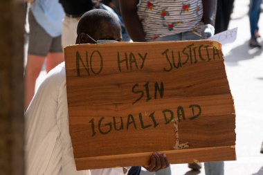 Palma, Mayorka, İspanya - 7 Haziran 2020: Siyahi adam ırkçılığa ve George Floyd 'un ölümüne karşı gösteri sırasında pankart tutuyor.