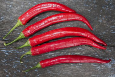 Ahşap bir arka planda kırmızı biber izole edilmiş. Baharat - Taze biberlerin parlak renkleri.