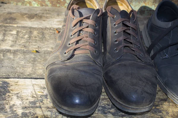 木桌上的旧皮鞋 — 图库照片
