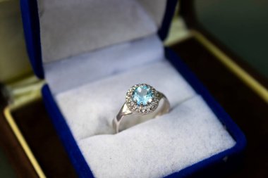 Mavi bir hediye kutusunda nişan yüzüğü.