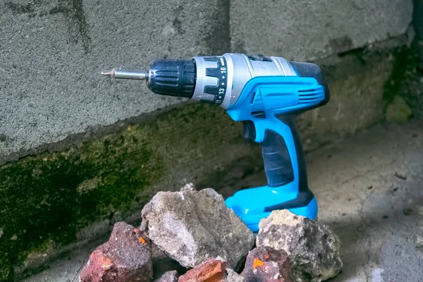 Electric screwdriver. Close up of electric drill on concrete background.