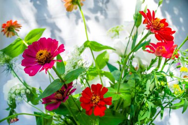 Bir demet leylak, beyaz, pembe ve mor östoma çiçekleri ve kırmızı zinya çiçekleri.