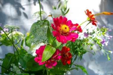 Bir demet leylak, beyaz, pembe ve mor östoma çiçekleri ve kırmızı zinya çiçekleri.