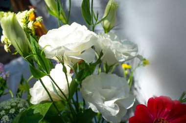 Bir demet leylak, beyaz, pembe ve mor östoma çiçekleri ve kırmızı zinya çiçekleri.