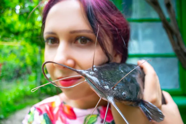 Uma Mulher Sorridente Vestido Rosa Segurando Grande Peixe Gato Cabeça — Fotografia de Stock