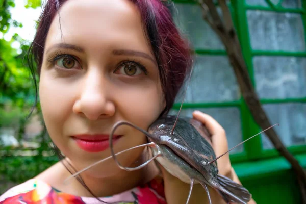 Uma Mulher Sorridente Vestido Rosa Segurando Grande Peixe Gato Cabeça — Fotografia de Stock