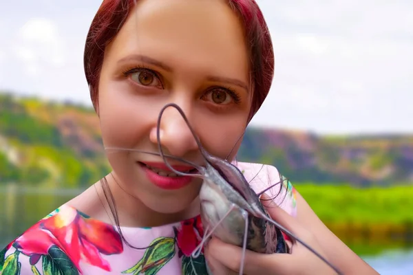 Una Mujer Sonriente Con Vestido Rosa Sosteniendo Gran Siluro Marrón — Foto de Stock