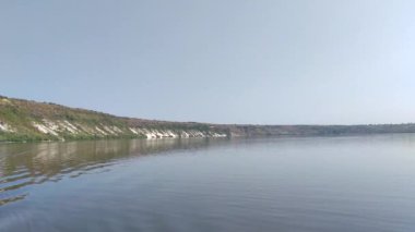 Dinyester Nehri 'nin sakin su yüzeyi ve açık yaz mevsiminde tepenin kara ufkuyla manzara