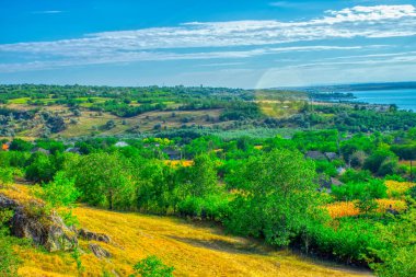 Yeşil tepeler, orman ufku olan çayırlar bulutlu mavi gökyüzüne karşı. Moldova 'nın Doğası
