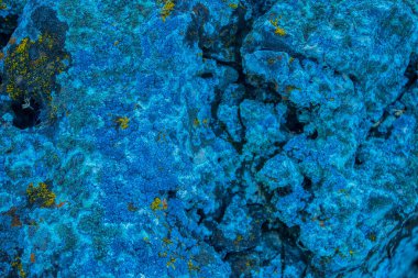 Yakından bakınca parlak mavi taştan bir kaya, pejmürde bir uçurum doku dağlarını çatlatıyor. Jeoloji kavramı, doğadaki güzellik gücü. Doğal yaz kompozisyonu arkaplan tasarımı