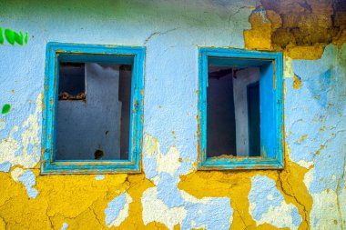 Pencereleri olan eski püskü, terk edilmiş bir ev.