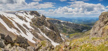 Dağ geçidinde. Kayalık yamaçlar, kar tarlaları ve küçük göller. Dağlarda ilkbahar.