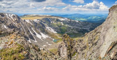 Dağ geçidinde. Kayalık yamaçlar, kar tarlaları ve küçük göller. Dağlarda ilkbahar.