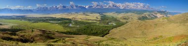 Over the mountain valley, snow-capped peaks in the clouds and green summer slopes, large panorama	 clipart