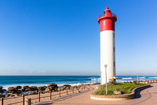 Bir tatil yaşam tarzı manzara mavi okyanus horizon ile plaj deniz feneri kırmızı beyaz yapısı closeup dalgalar.