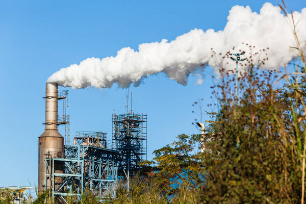 Завод по производству стальных силосных башен трубы стэк конструкций с дымом по всему голубому небу ландшафта
.