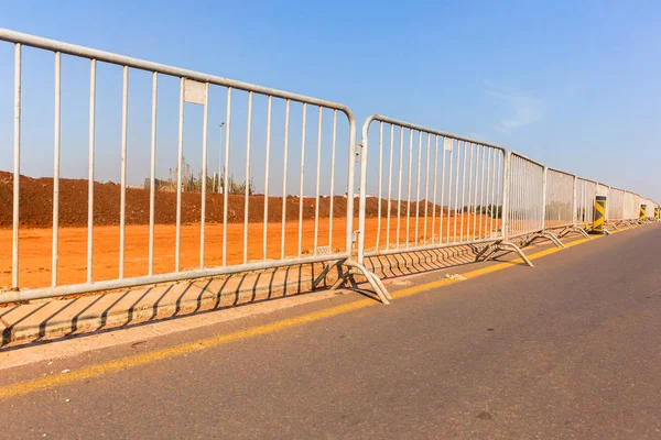 Portable fencing steel sections linked together on roadside at construction site.