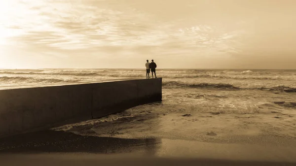 Father Son Fishing Silhouetted Unidentified Beach Jetty Waters Edge Ocean — Stock Photo, Image