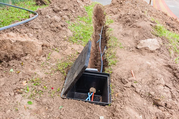 New internet fast speed fiber optic cables been installed underground in trenches along road front of residential homes .