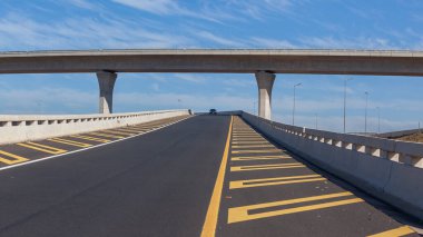 Otoyol Çıkış Girişi Rampa uzak araç yeni seyahat güzergahları mavi gökyüzünde yeni boş asfalt yapı ortasında duruyor.