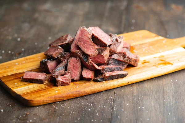 Fatias de bife em uma tábua de corte pronta para servir — Fotografia de Stock