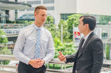 İş ortakları yürüyüş yolunun halka açık alanında konuşuyor.